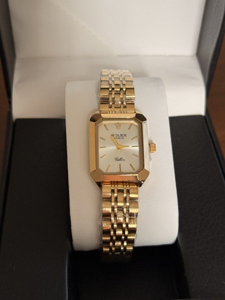 ساعة رولكس  شكل مستطيل ستاتي ذهبي ارضية ابيض مع علبة